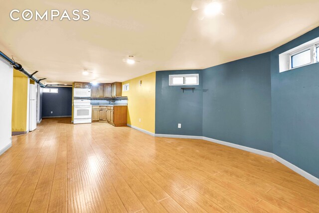 unfurnished living room featuring light wood-style floors and baseboards