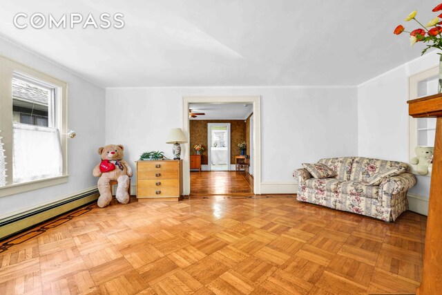 living area featuring baseboards and a baseboard heating unit