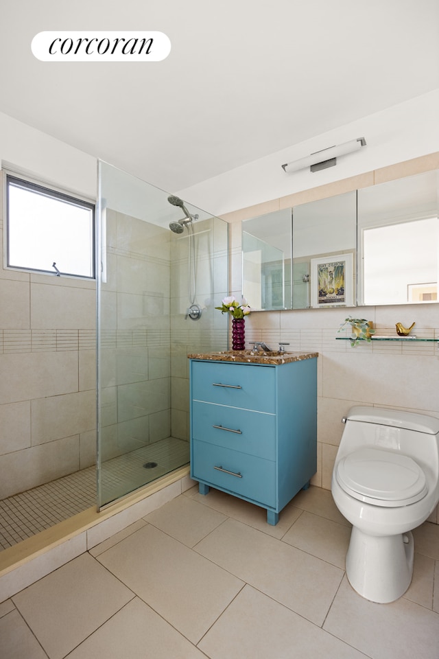 full bath with tiled shower, tile patterned floors, toilet, and vanity