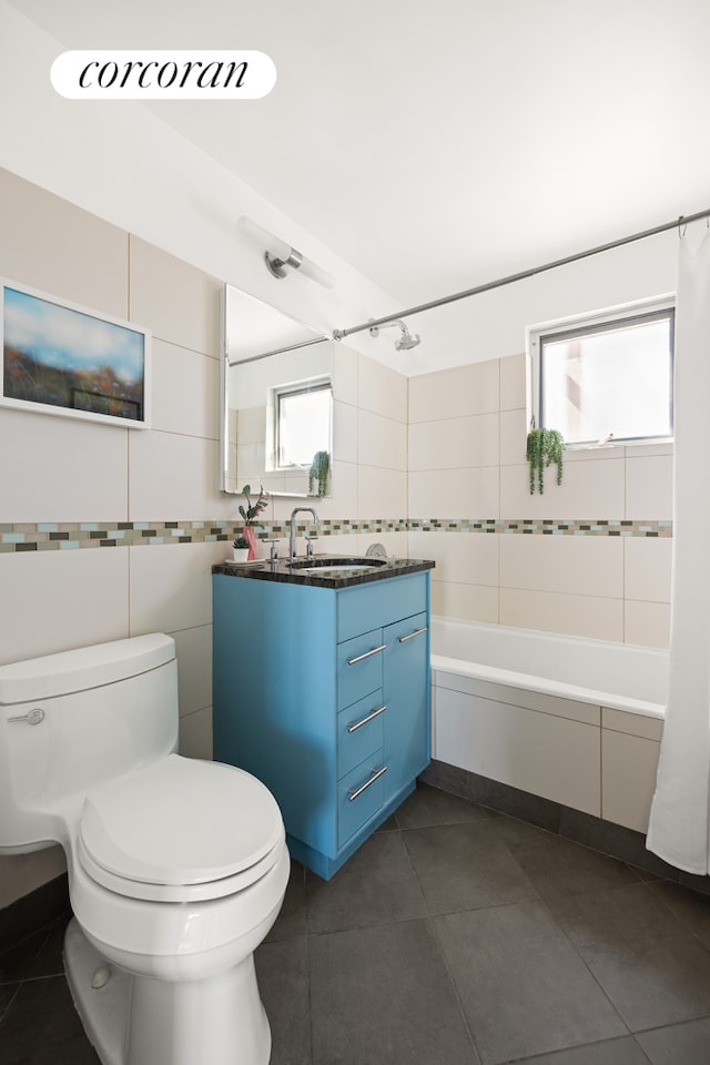 full bath with toilet, tile walls, bathing tub / shower combination, vanity, and tile patterned flooring