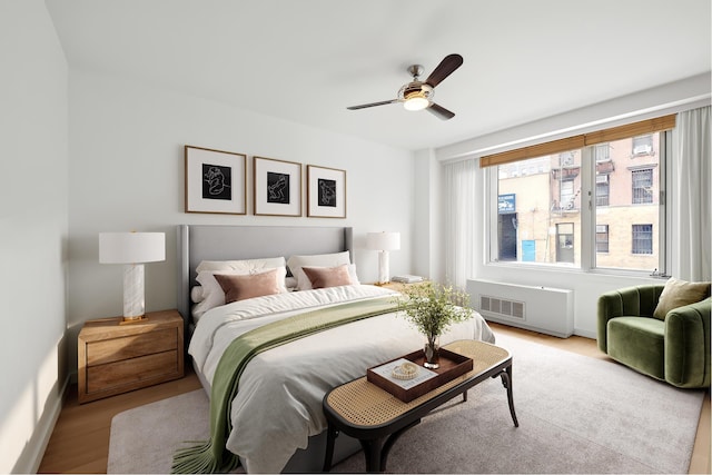 bedroom with baseboards, a ceiling fan, and light wood-style flooring