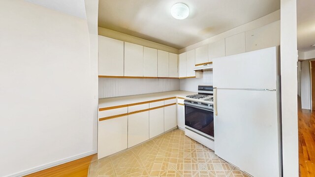 kitchen featuring light countertops, under cabinet range hood, white appliances, and white cabinetry