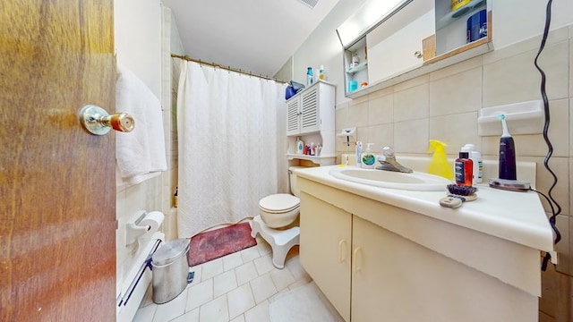 bathroom with tile patterned flooring, vanity, toilet, tile walls, and a baseboard radiator