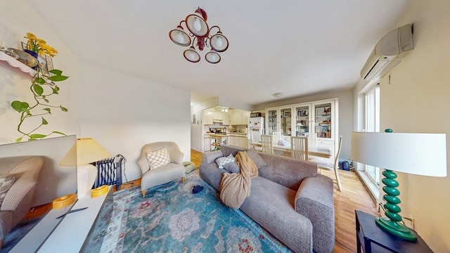 living area with light wood finished floors and a wall unit AC