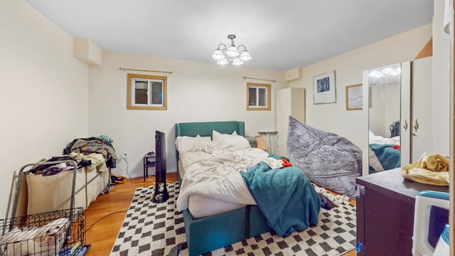 bedroom featuring wood finished floors and a notable chandelier