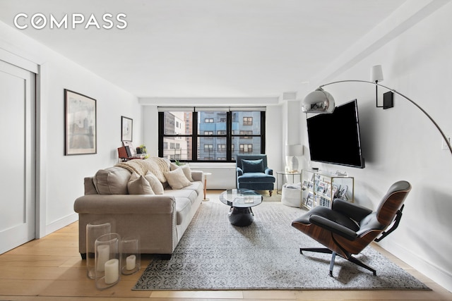 living area with baseboards and wood finished floors