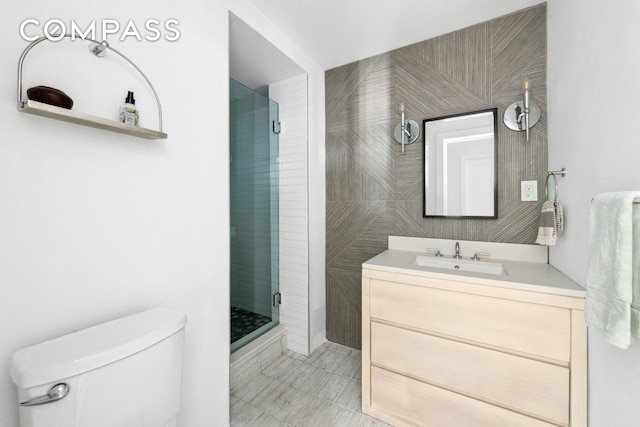 bathroom featuring vanity, toilet, and a shower stall