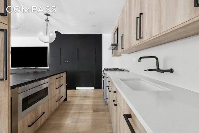 kitchen featuring a sink, light brown cabinetry, and modern cabinets