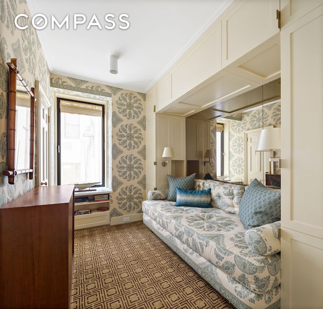 living area featuring wallpapered walls, baseboards, and crown molding