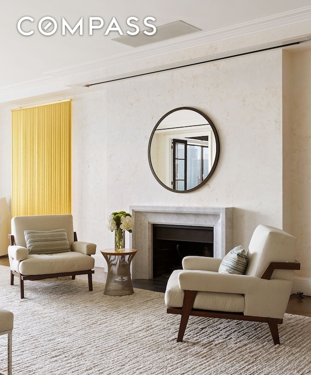 sitting room featuring crown molding, a fireplace, and wood finished floors