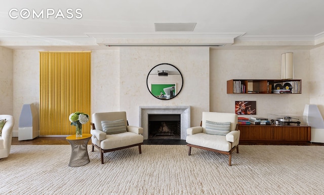 sitting room with crown molding, a premium fireplace, wood finished floors, and baseboards
