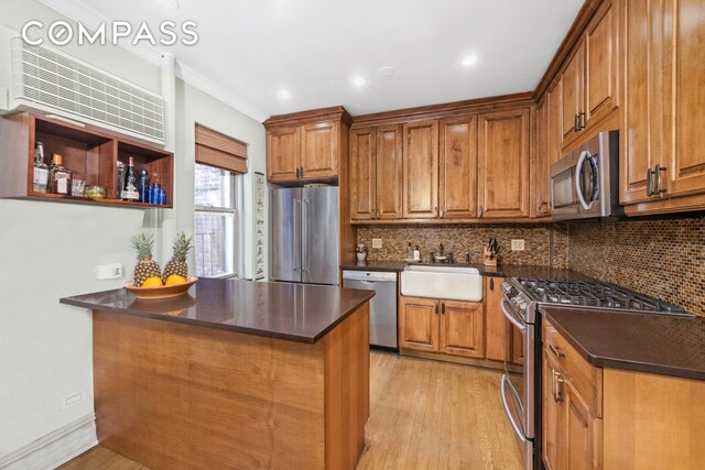 kitchen with brown cabinetry, dark countertops, and stainless steel appliances