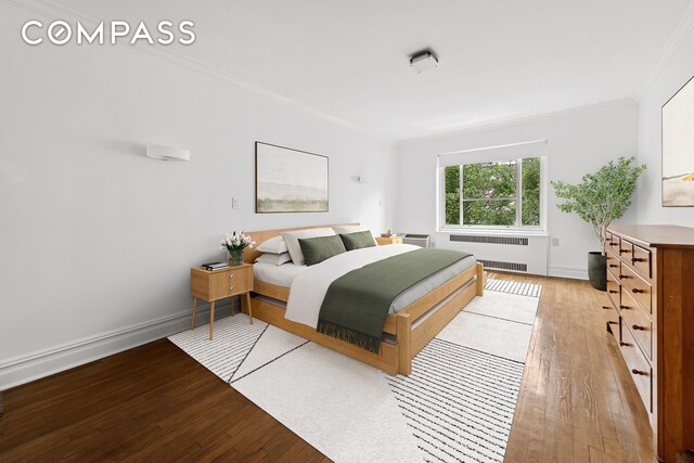 bedroom featuring baseboards, ornamental molding, radiator, and light wood-style flooring