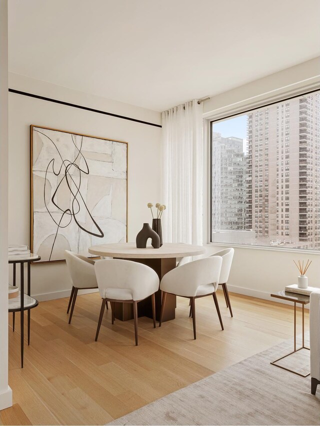 611 W 56th St Unit 12, New York City, NY 10019 - dining area with light wood finished floors and baseboards