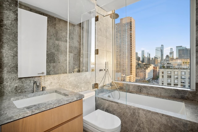 611 W 56th St Unit 12, New York City, NY 10019 - bathroom featuring a view of skyline, toilet, a combined bath / shower with marble appearance, tile walls, and vanity