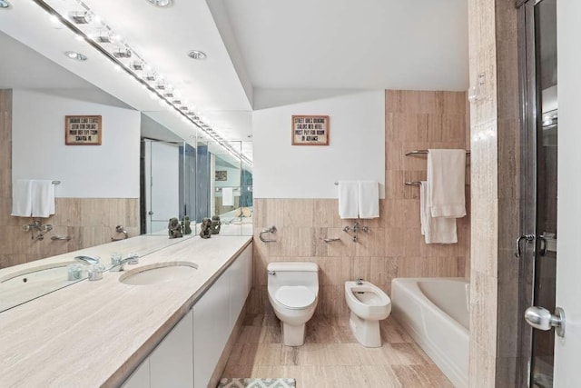 bathroom featuring a bath, toilet, tile walls, a bidet, and vanity
