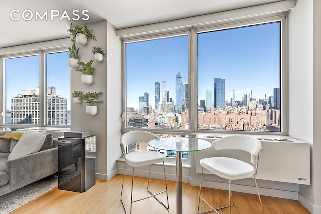 450 W 17th St Unit 2302, New York City, NY 10011 - dining room with a skyline view, wood finished floors, and baseboards