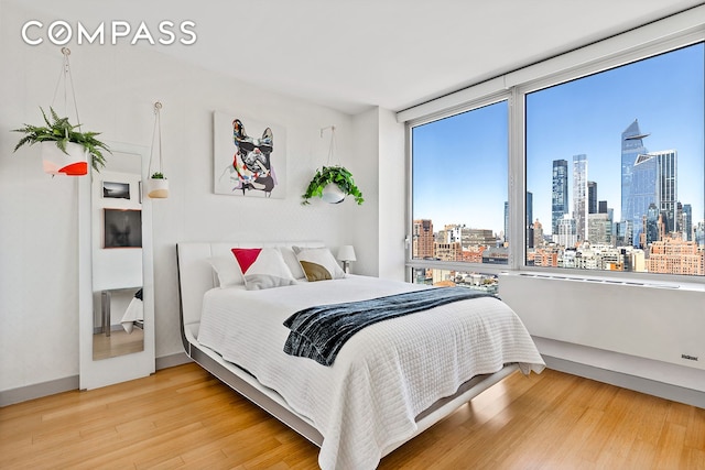 450 W 17th St Unit 2302, New York City, NY 10011 - bedroom featuring a skyline view and wood finished floors