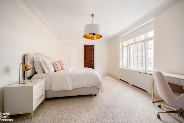 bedroom featuring crown molding, light colored carpet, a desk, and multiple closets