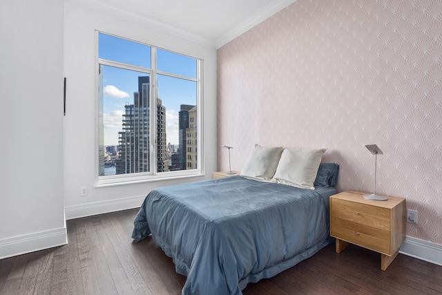 bedroom with hardwood / wood-style floors, crown molding, baseboards, and a view of city