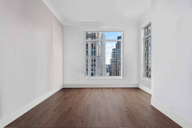 unfurnished room featuring a city view, wood finished floors, and ornamental molding