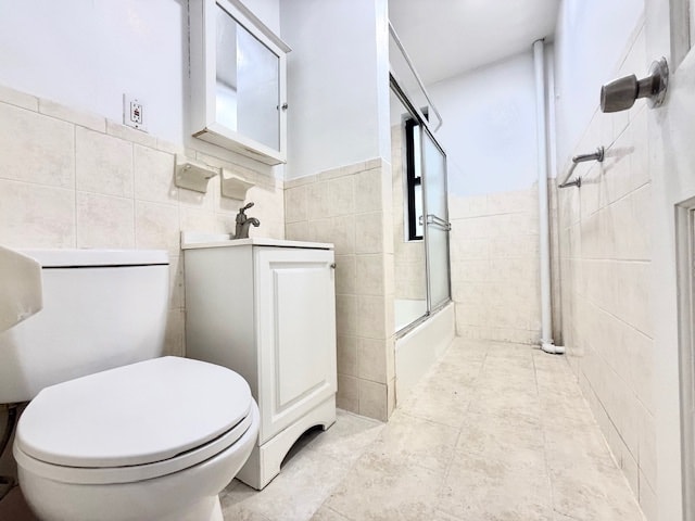 504 W 139th St Unit 14, New York City, NY 10031 - bathroom featuring tile walls, vanity, enclosed tub / shower combo, and tile patterned floors