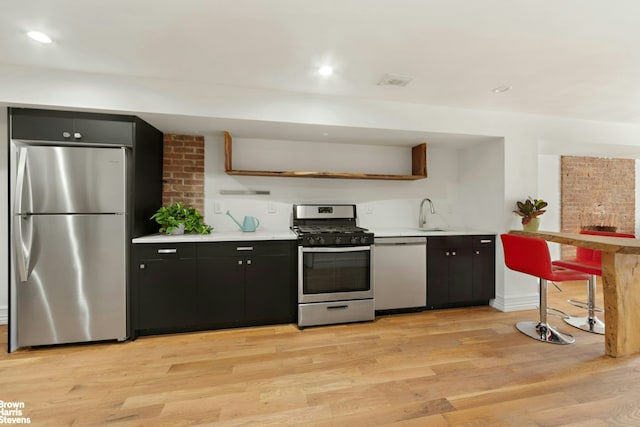 kitchen with light wood-style floors, recessed lighting, a sink, light countertops, and stainless steel appliances