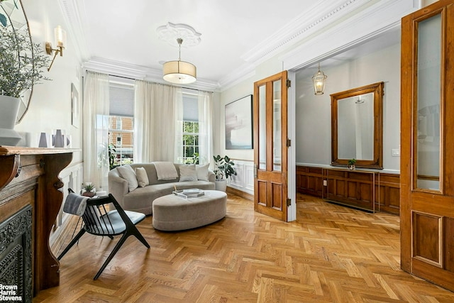 sitting room with a fireplace, a decorative wall, ornamental molding, and a wainscoted wall