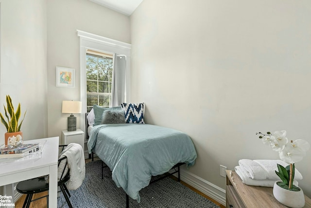 bedroom with baseboards and wood finished floors