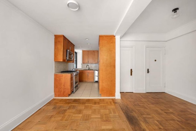 260 W End Ave Unit 3D, New York City, NY 10023 - kitchen with stainless steel appliances, baseboards, brown cabinets, and backsplash