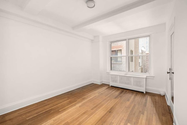 260 W End Ave Unit 3D, New York City, NY 10023 - empty room featuring radiator heating unit, light wood-type flooring, baseboards, and beam ceiling