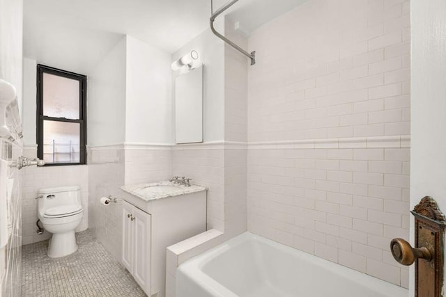 260 W End Ave Unit 3D, New York City, NY 10023 - bathroom with toilet, vanity, tile patterned floors, tile walls, and wainscoting