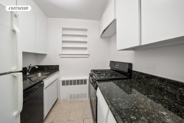 167 E 67th St Unit 7E, New York City, NY 10065 - kitchen featuring black appliances, radiator heating unit, a sink, white cabinets, and dark stone countertops