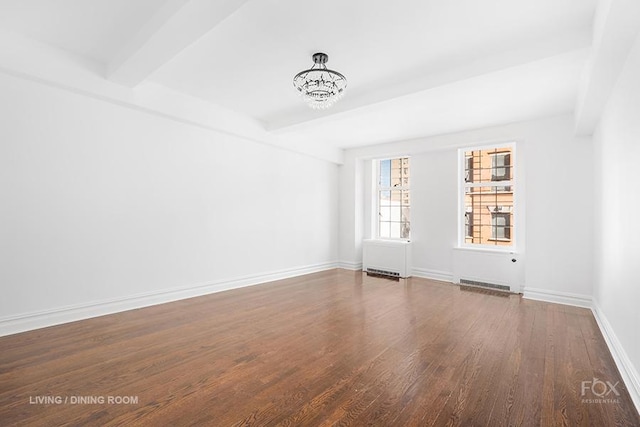 spare room with wood finished floors, baseboards, beam ceiling, and a chandelier