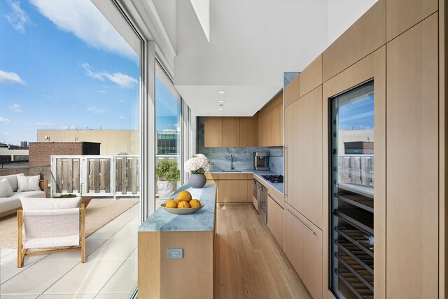 611 W 56th Street Maisonwest, New York City, NY 10019 - kitchen featuring a sink, open floor plan, light wood-style floors, modern cabinets, and backsplash