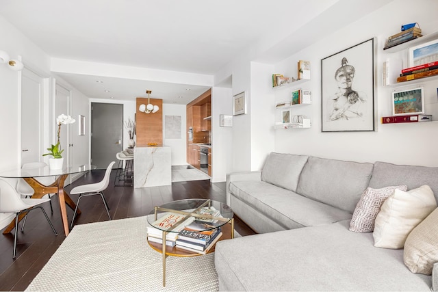 living area featuring dark wood-type flooring and a chandelier
