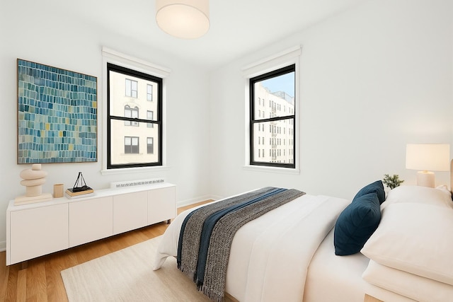 bedroom featuring wood finished floors and baseboards