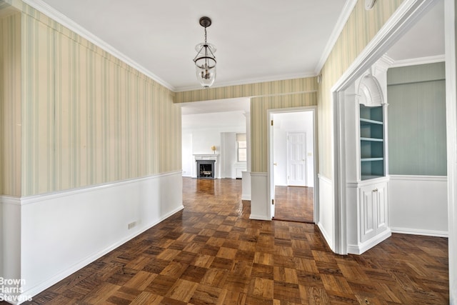 corridor with wallpapered walls, baseboards, crown molding, and wainscoting