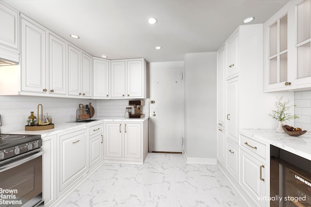 kitchen featuring stainless steel range with electric stovetop, recessed lighting, white cabinets, tasteful backsplash, and light marble finish flooring