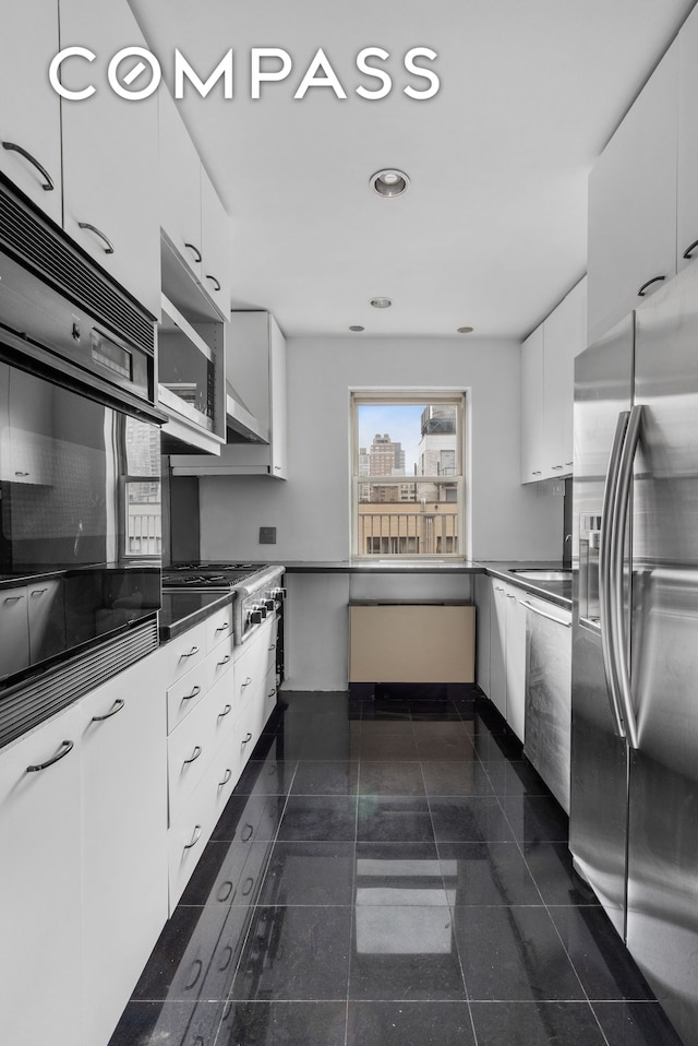 333 E 66th St Pha, Pha, New York City, NY 10065 - kitchen with appliances with stainless steel finishes, white cabinetry, dark countertops, recessed lighting, and modern cabinets