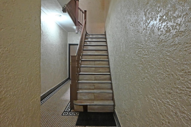 10-53 115th St, New York City, NY 11356 - stairway featuring a textured wall and baseboards
