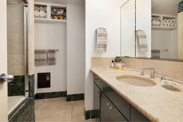 bathroom with vanity, tiled shower / bath combo, and tasteful backsplash