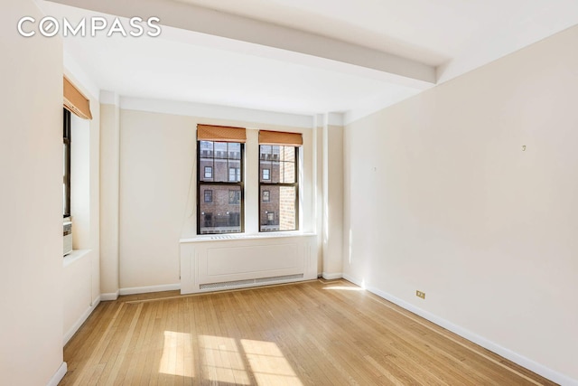 spare room featuring light wood-style flooring and baseboards