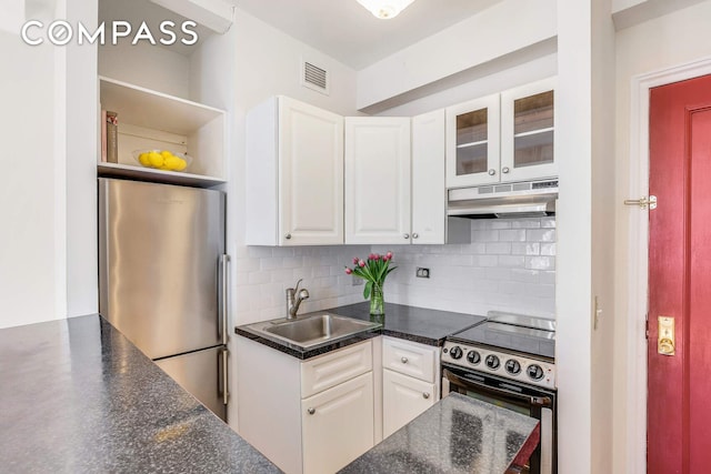 kitchen with appliances with stainless steel finishes, a sink, under cabinet range hood, dark countertops, and white cabinets
