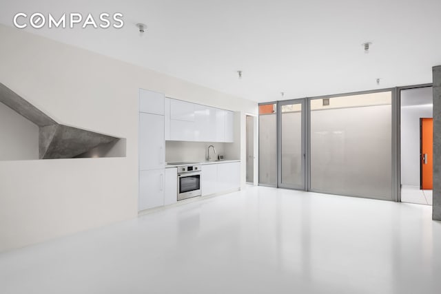 unfurnished living room with concrete flooring and a sink