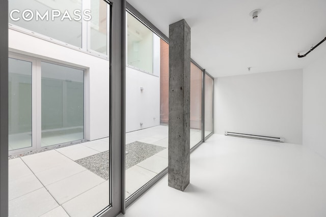 interior space featuring a baseboard radiator and a patio area