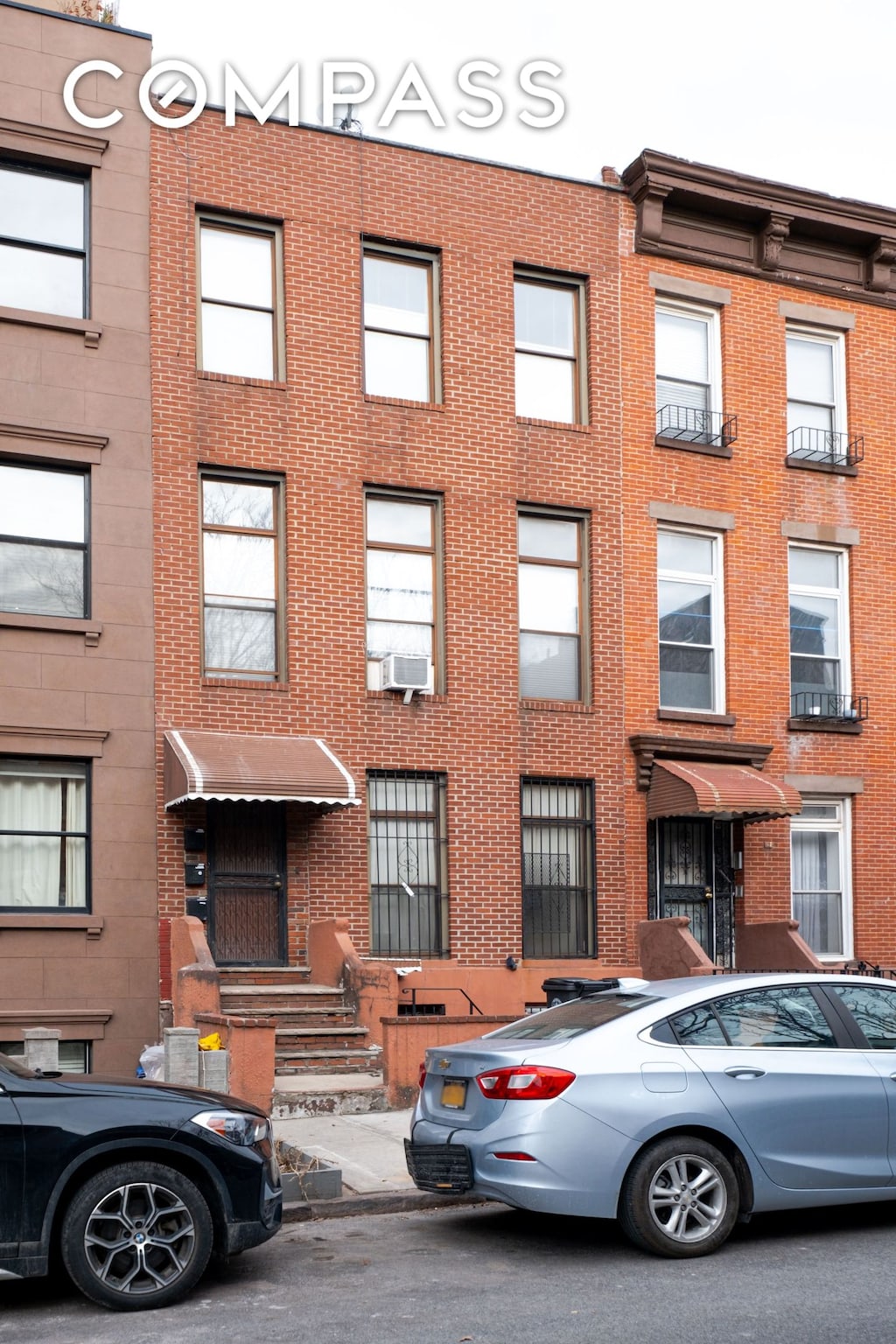 townhome / multi-family property with brick siding and cooling unit