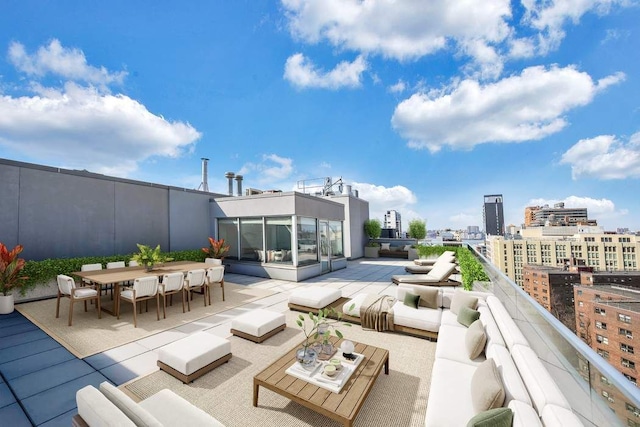 view of patio featuring a view of city, outdoor dining space, an outdoor living space, and a balcony