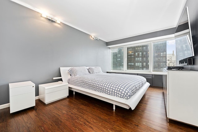 bedroom with wood finished floors and baseboards