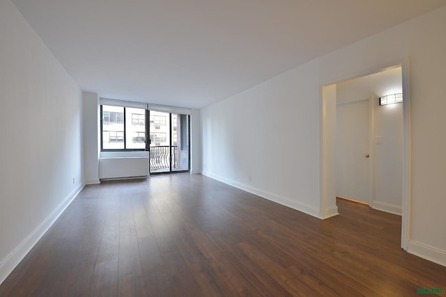 343 E 74th St Unit 7-J, New York City, NY 10021 - empty room featuring dark wood-style flooring and baseboards
